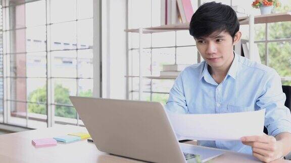 在家工作亚洲男性员工在家里用笔记本电脑与同事进行视频通话