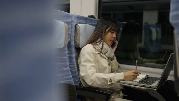 4K亚洲女性在火车上用笔记本电脑工作打手机