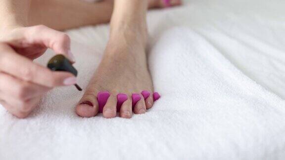 女人用美甲刷在腿上画指甲