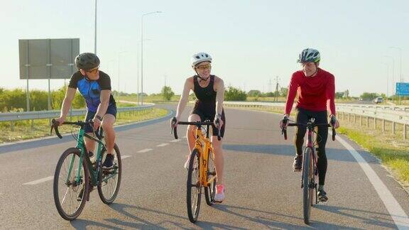一名女子和两名男子在新鲜空气中骑着运动自行车