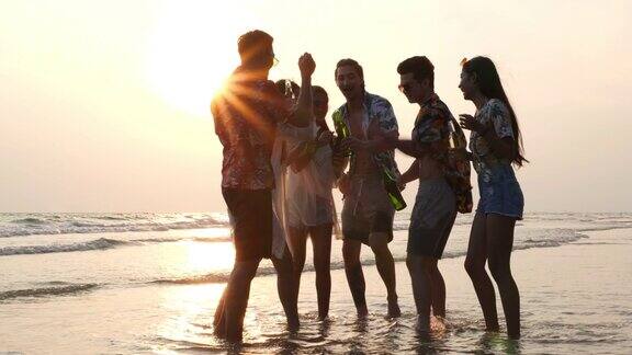 亚洲朋友庆祝快乐在海滩上喝啤酒旅行旅行者年轻人一起打碎啤酒瓶朋友们一起喝混合酒精和啤酒4K超高清慢动作