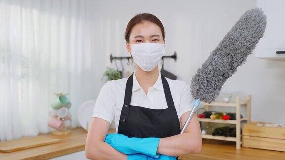 亚洲年轻清洁服务女工在房子工作的肖像美丽的女管家清洁工戴着口罩交叉手臂微笑在做家务或家务后看着镜头