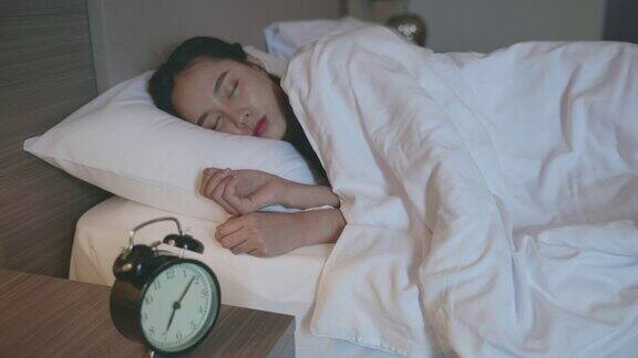 一个亚洲女人睡在卧室的床上