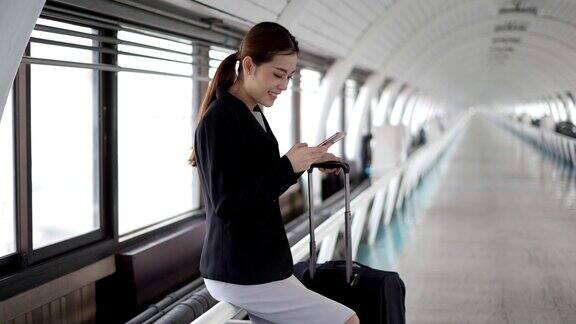 女乘客在机场用智能手机等待航空旅行
