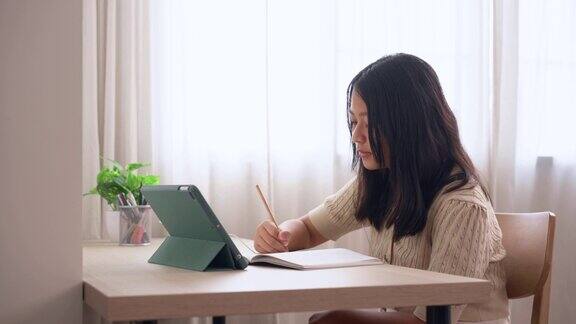 一个女孩和她在家里用平板电脑在线学习的老师交谈教育在线学习