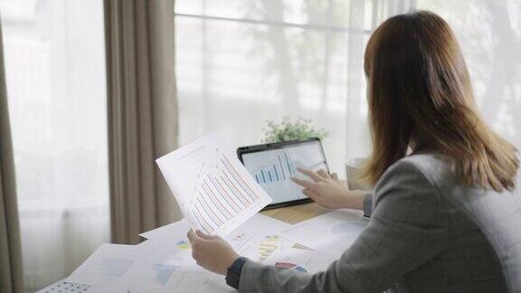女商人在办公室使用平板电脑和文档图表