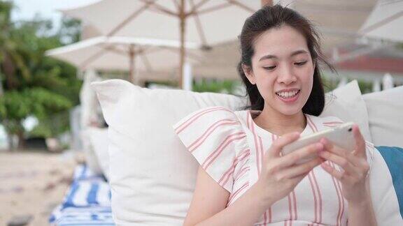 年轻的z一代亚洲中国女性使用智能手机5G玩手机游戏度假放松