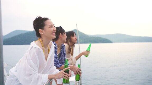 4K一群亚洲女性朋友一起在日落时分的海上豪华游艇上喝啤酒