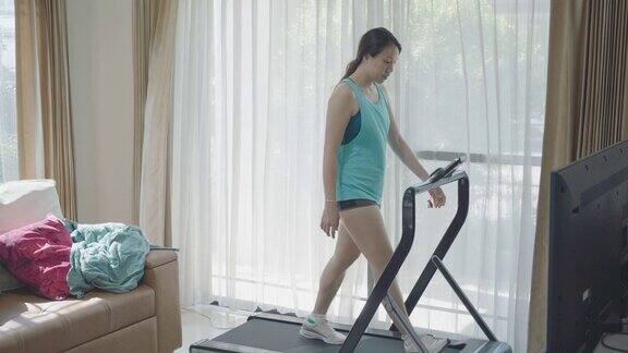 女人在跑步机上跑步在家健身房锻炼