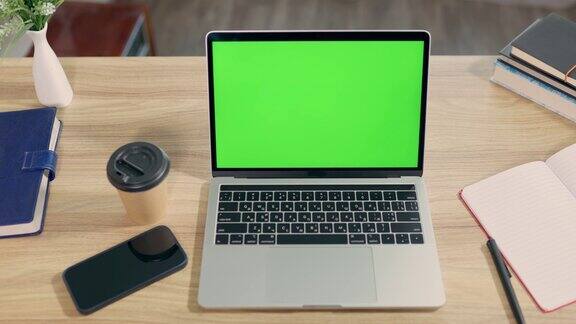 笔记本电脑与绿色模拟屏幕在桌面舒适的家庭办公室