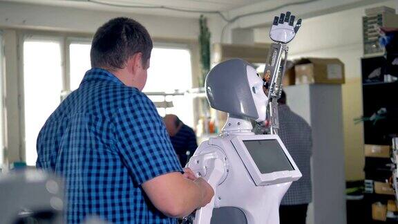 工程师将手臂连接到机器人的身体框架上
