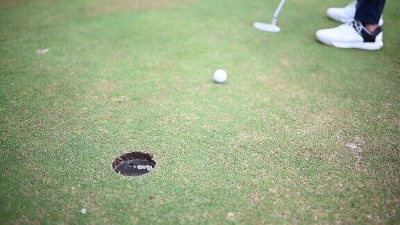 亚洲华人男子高尔夫球击到高尔夫球场的高尔夫洞的特写镜头