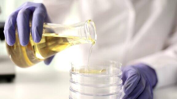 在实验室特写中化学家将黄色有毒油液倒入试管中