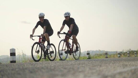 两名运动男子通过骑自行车锻炼在中午日落前的时间