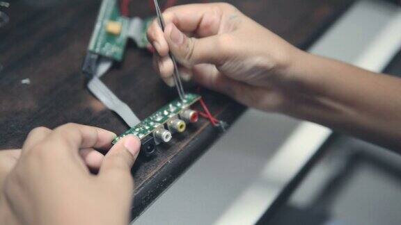 十几岁的男孩检查和清洁电子电路板修理后