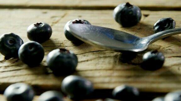 新鲜蓝莓和勺子放在4k木桌上