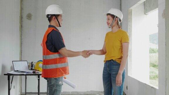 施工工程师与施工现场业主握手同意加盟业务工作