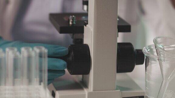 科学家在分析样品时调整显微镜的焦点