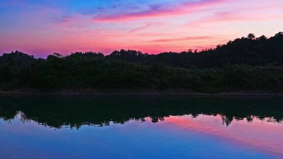 夕阳下清澈的湖面映着彩云