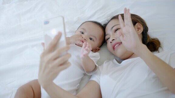 宝宝和妈妈在床上视频通话和自拍家庭关系