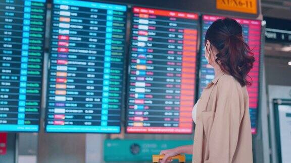 亚洲女旅客在机场候机楼查看航班时刻表旅游旅程旅行概念