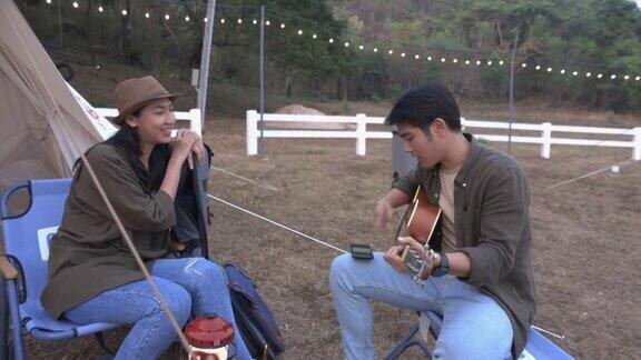 年轻的亚洲夫妇弹着吉他一起唱着歌