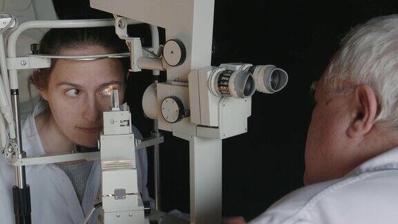 裂隙灯视力检查年轻女子在眼科医生检查眼睛白领工人活跃的老年人在他们的工作场所