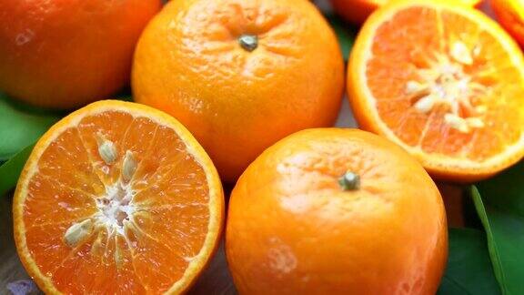 俯视图旋转橙子切片特写新鲜的橙子水果与绿色的叶子在花园里