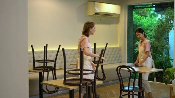 4K年轻的亚洲女服务员在咖啡店开业前打扫