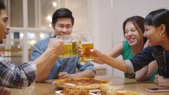 年轻快乐的亚洲朋友群男女享受放松的夜晚聚会活动庆祝节日在咖啡馆餐厅下班后喝杯啤酒坐下来聊聊天