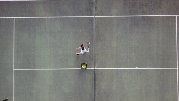 无人机视角的亚洲女子网球选手发球在网球的正上方练习