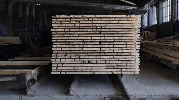 在宽敞的现代化锯木厂加工后大量堆积的木板为建造或运输准备的相同大小和形状的折边木材木工工业