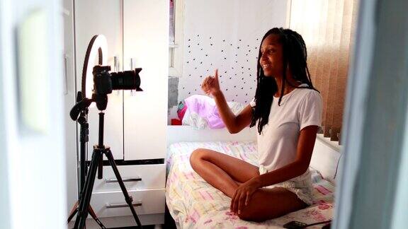 一个非洲女孩在镜头前说话黑人女影响少年为粉丝制作视频