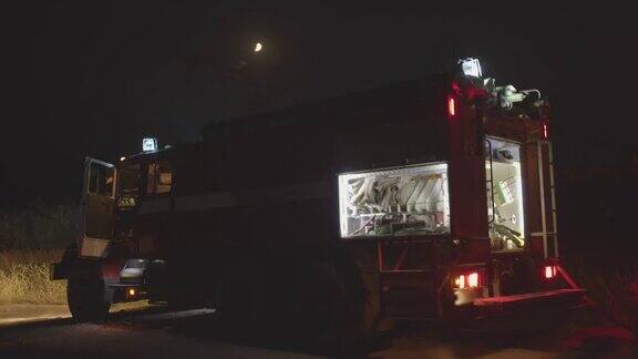 闪灯的消防车森林大火中消防车在草地上燃烧自然灾害的救助和预防