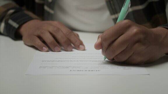 黑人用笔在协议上签字不认识的人在纸上写字