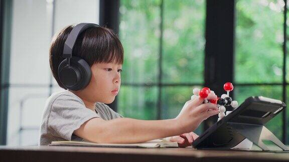 亚洲小男孩组装分子模型在家学习与学校老师在线教学在家教育的孩子通过远程应用与老师练习思考逻辑和会议