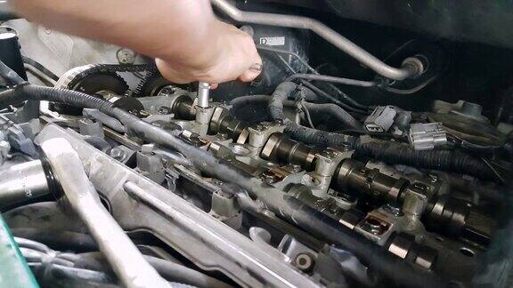 机械师用套筒扳手固定汽车发动机凸轮轴气缸盖