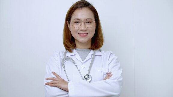 聪明的医生亚洲女医生站在她的双臂交叉和微笑自信