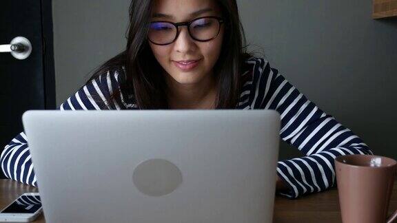 年轻女子用眼镜和笔记本电脑工作