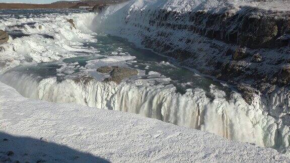冰岛冰冻瀑布的特写与冰冷的岩石和流动的水冰冻的冬季景观与冰雪神奇的大自然冬天纯净的冰川水著名的旅游景点