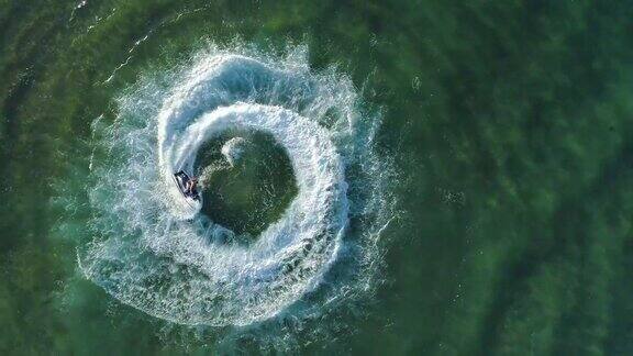 4K直线下降缩小壮观的鸟瞰图的人有乐趣骑在一个个人的水上船在海洋做一个圆形的模式莫桑比克
