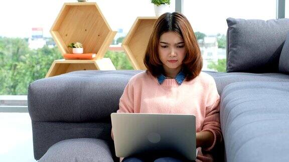 年轻美丽的亚洲女人在家里用笔记本电脑工作人与科技在家里工作在线教育