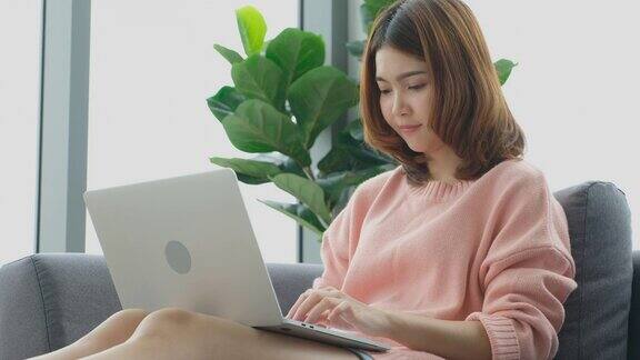 年轻美丽的亚洲女人在家里用笔记本电脑工作人与科技在家里工作在线教育