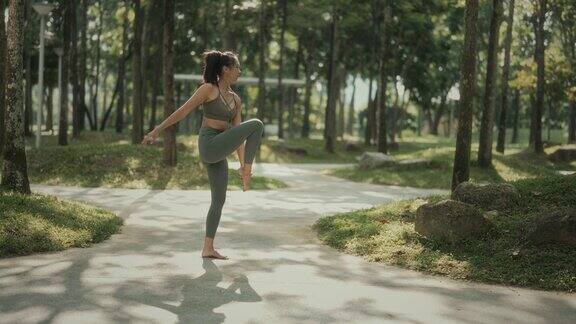 周末早上一名亚裔华裔女子在公园里练习瑜伽