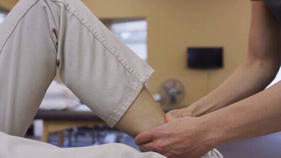 女性理疗师的手按摩女性小腿肌肉的特写