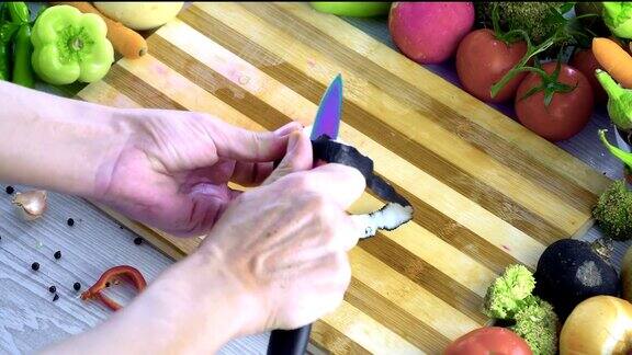 男人在厨房里切蔬菜用慢镜头切西红柿