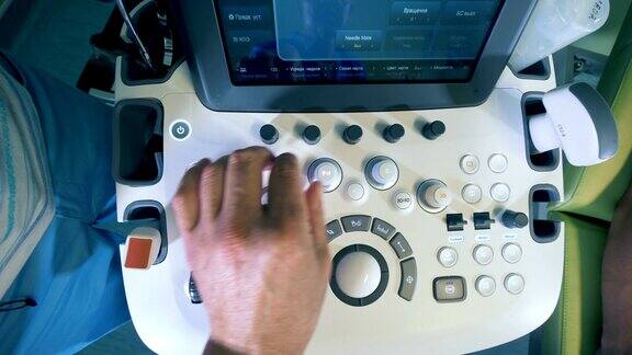 男医生在超声波设备上按下按钮俯视图