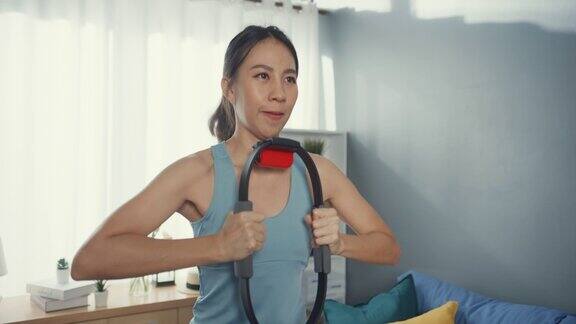 年轻有吸引力的亚洲妇女与运动服装使用戒指健身游戏玩开关游戏拳击锻炼在线程序在客厅在房子居家隔离大流行封锁活动概念