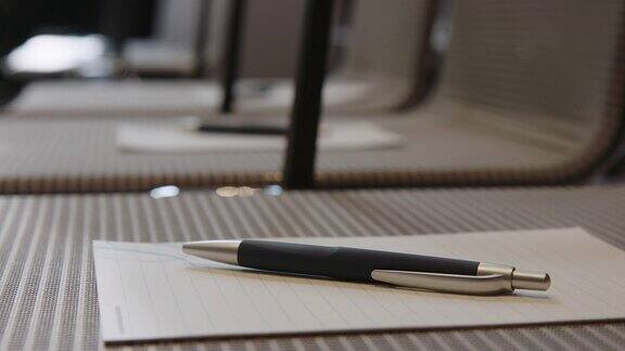 在会议中心的椅子上放置带笔的便笺本