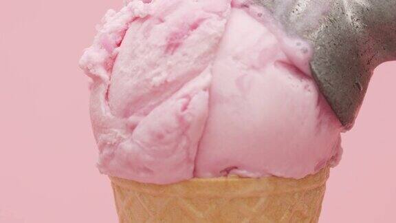 手勺冰淇淋草莓在华夫饼筒孤立在粉红色的背景